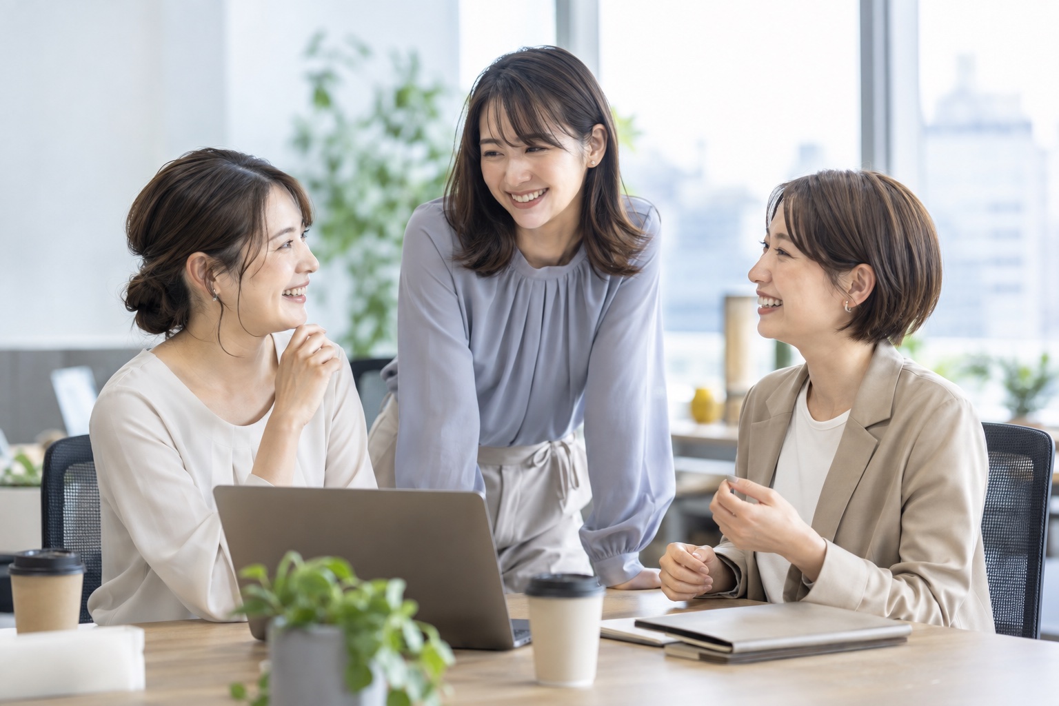 笑顔で会話するオフィスの社員イメージ